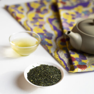 Foglie di tè, tazzina, stoffa e teiera kyusu