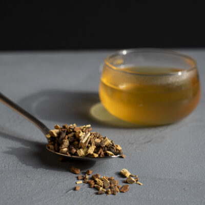 Una tazza colma di tisana e un cucchiaio pieno di spezie