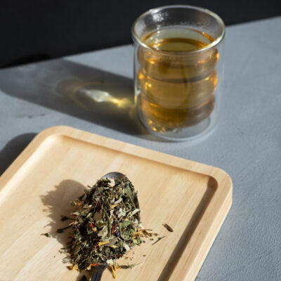 Un bicchiere di tisana e foglie sciolte