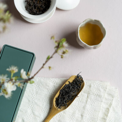 Foglie di tè asciutte, foglie infuse e una tazzina di tè