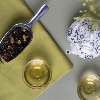 Foglie di tè, una piccola teiera e due tazzine