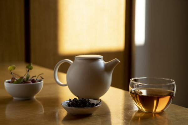 una teiera e una tazza di tè con lo sfondo di una luce calda