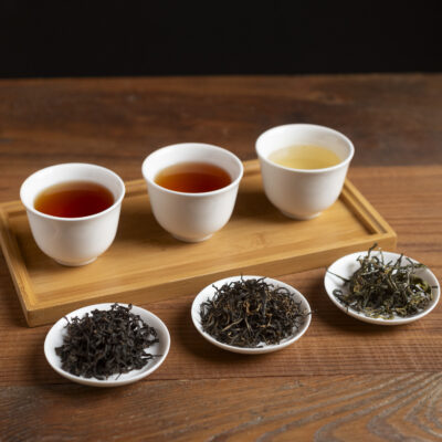 Tre tazze di tè con le rispettive foglie asciutte