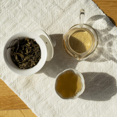 Gaiwan aperta con foglie infuse, brocca e tazzina